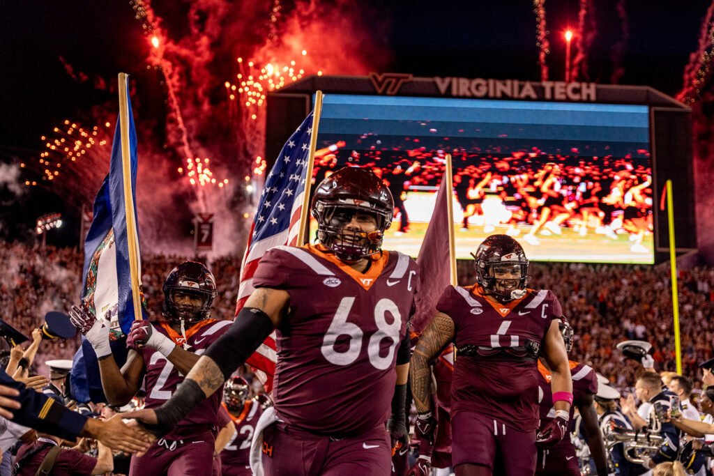 Virginia Tech football’s iconic tradition has deep roots, centered around the electrifying entrance to “Enter Sandman.” This ritual began in 2000 and quickly became one of college football’s most intense pregame experiences. As the song blares, fans jump in unison, shaking Lane Stadium and creating an unmatched atmosphere. The tradition reflects Hokie pride, uniting students, alumni, and players. Over time, it’s become more than just an entrance—it’s a symbol of Virginia Tech’s spirit, energy, and football culture.