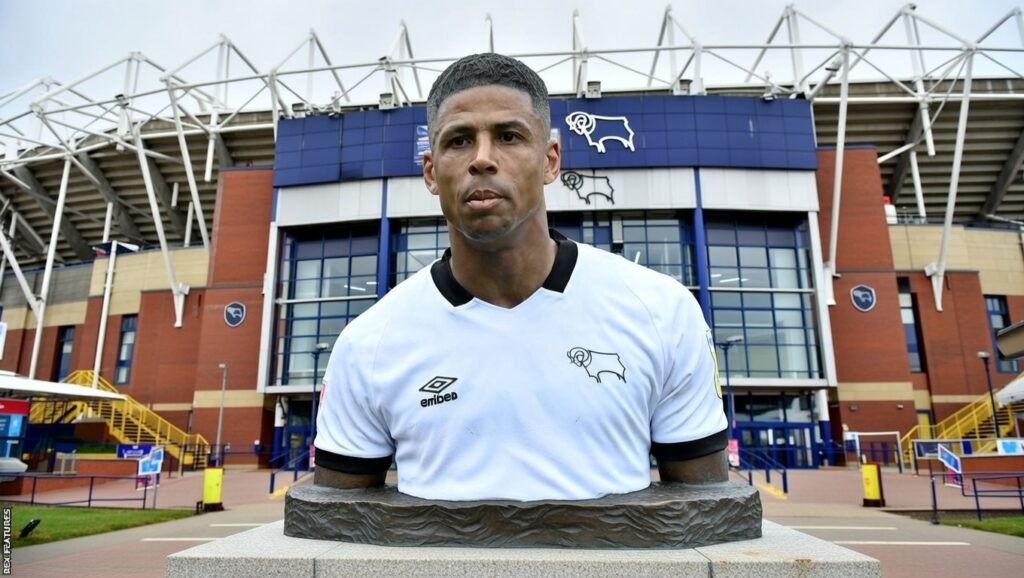 Derby County detonates emotion! 💥🐏 Curtis Davies, the iron captain who dragged the Rams from League One to glory, is cast in BRONZE outside Pride Park! 🏟️🔥 Goosebumps everywhere. Fans erupt. History freezes forever. And the twist? The statue was secretly funded by supportersâone pound, one heartbeat, one legend reborn. A fairytale return shaking Derby to its very core tonight forevermore now