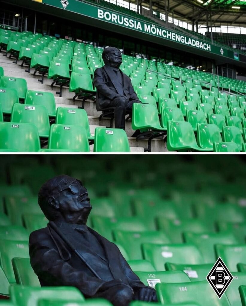 Im ikonischen Borussia-Park von Borussia Mönchengladbach bleibt eine stille Gestalt auf der Tribüne für immer unvergessen 😢🖤 Eine Statue eines treuen Fans sitzt nun auf seinem Stammplatz. Selbst nachdem er durch Krankheit sein Augenlicht verlor, verpasste er kein einziges Spiel – geführt von der Stimme seines loyalen Sohnes ⚽👨👦 In der Dunkelheit erlosch seine Leidenschaft nie. Der Verein verewigte seine Hingabe und Treue in Bronze 🫶🔥 Heute sitzt sein Sohn bei jedem Spiel weiterhin neben ihm – Liebe, stärker als jeder Stadionjubel ❤️🏟️ Legenden stehen nicht nur auf dem Rasen.